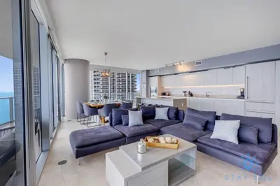 a living room with a blue couch and a kitchen at Oceanview Luxury 3BR Sky Home Amaizing Pool in Hollywood