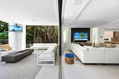 a living room with white furniture and a flat screen tv at Villa Celine in Fort Lauderdale