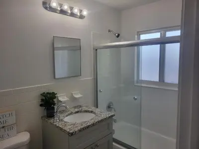 a bathroom with a sink and a glass shower at Arpe 4plex in Fort Lauderdale