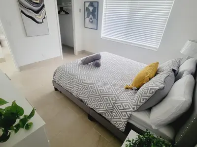 a bed in a living room next to a couch at Arpe 4plex in Fort Lauderdale