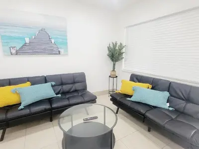 a living room with a couch and a glass table at Arpe 4plex in Fort Lauderdale
