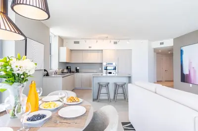 a living room and kitchen with a table with food on it at Amazing Pools Luxury 2Br Front Ocean Bay View in Hollywood