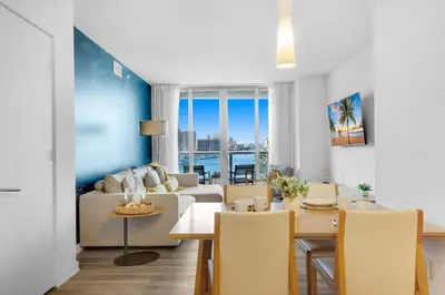 a living room with a couch and a table at Amazing Pool Apartment with Balcony Near Beach in Hallandale Beach