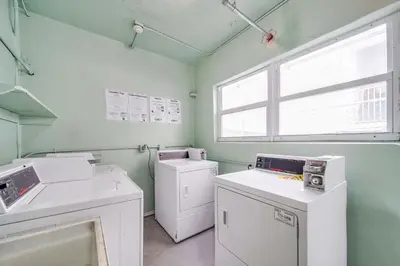 a laundry room with white appliances and a window at Ocean Drive Prime Apt w/2 QueenBeds & Washer/Dryer in Miami Beach