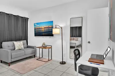 a living room with a couch and a desk with a laptop at Hollywood Beach Getaway Executive Studio Suite in Hollywood