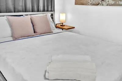 a bedroom with a large white bed with a lamp at Executive Studio Suite Hollywood Beach Blvd in Hollywood