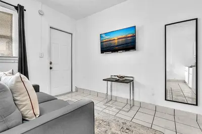 a living room with a couch and a tv on the wall at Executive Studio Hollywood Blvd & Near Beach in Hollywood