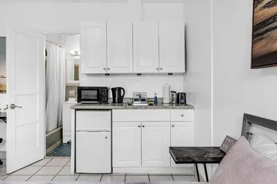 a kitchen with white cabinets and a microwave at Executive Studio Hollywood Blvd & Near Beach in Hollywood