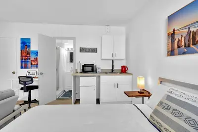 a white room with a bed and a kitchen at Hollywood Blvd Near The Beach 