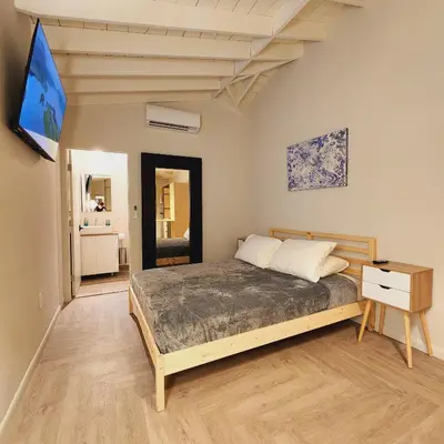 a bedroom with a bed and a tv on the wall at Private Home Studio Central Located in Miami 1 in Opa-locka