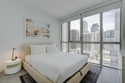 a bedroom with a white bed and a large window at 227-2500FU DOWNTOWN MIAMI 1 BEDROOM CONDO in Miami
