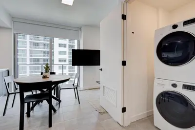 a dining room with a table and a washer and dryer at 1912AA DOWNTOWN MIAMI STUDIO in Miami