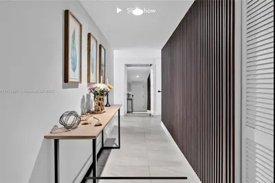 a hallway of a home with white walls and a table at Apartment 3B/3B Stunning view of the intercostal in Hallandale Beach