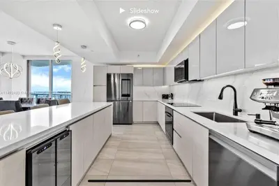 a kitchen with white appliances and a large window at Apartment 3B/3B Stunning view of the intercostal in Hallandale Beach