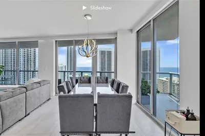 a dining room with a table and chairs and windows at Apartment 3B/3B Stunning view of the intercostal in Hallandale Beach