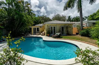a swimming pool in the yard of a house at Family Escape 2BR Main plus 1BR Cottage Heated Pool in Fort Lauderdale