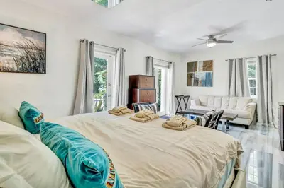 a bedroom with two beds and a living room at Family Escape 2BR Main plus 1BR Cottage Heated Pool in Fort Lauderdale