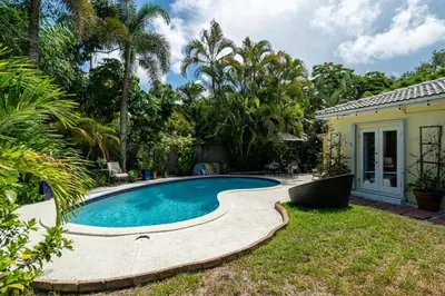 a swimming pool in the yard of a house at Charming Cottage 1BR, Pool, Victoria Park in Fort Lauderdale