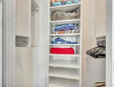 a walk in closet with white shelves and towels at Family Home 2BR Heated Pool, Victoria Park in Fort Lauderdale