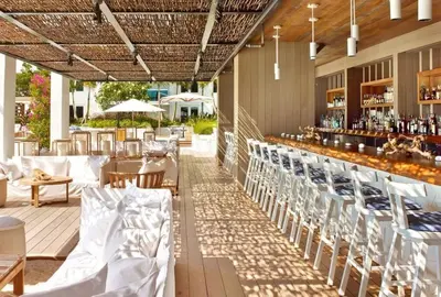 a restaurant with white chairs and a bar at Oceanview 1 Hotel & Homes 1 Bedroom 1 and Half Bathrooms Luxe Condo with Balcony in Miami Beach