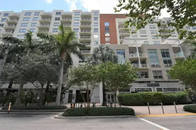 a large apartment building with trees in front of it at Lovely Midblock building 1 bedroom 1 bathroom apartment in Miami