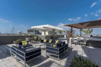 a patio with couches and tables on a roof at Lovely Midblock building 1 bedroom 1 bathroom apartment in Miami