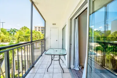 a balcony with a bench and a view of palm trees at Le Cartier Apartments Sunny Isles in Sunny Isles Beach