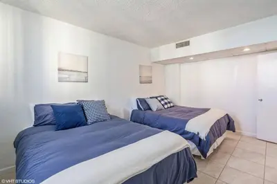 two beds in a bedroom with blue and white at Tides building over the beach apartments in Hollywood