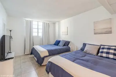 a bedroom with two beds and a flat screen tv at Tides building over the beach apartments in Hollywood