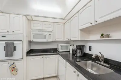 a white kitchen with white cabinets and white appliances at Tides building over the beach apartments in Hollywood