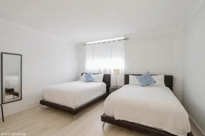a bedroom with two beds and a mirror at Tides building over the beach apartments in Hollywood