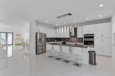 a kitchen with white cabinets and stainless steel appliances at Miami Oasis Villa, Your Luxury Haven in Tamiami