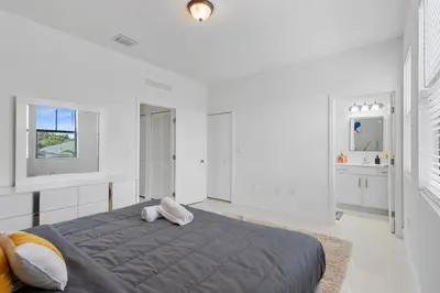 a white bedroom with a bed and two windows at Miami Oasis Villa, Your Luxury Haven in Tamiami