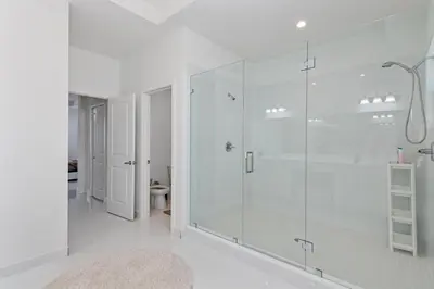 a white bathroom with a glass shower stall at Miami Oasis Villa, Your Luxury Haven in Tamiami