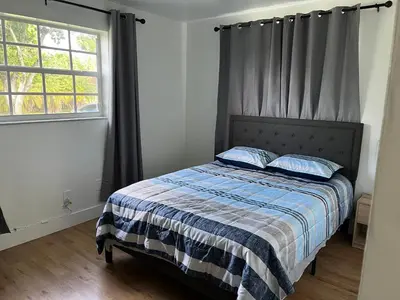 a bedroom with a bed with a blue and white blanket at Edercozy in Miami