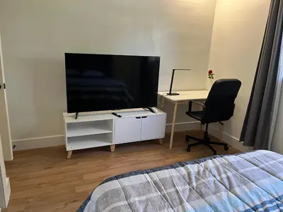 a bedroom with a tv and a desk with a chair at Edercozy in Miami