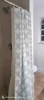a shower curtain in a bathroom next to a toilet at Edercozy in Miami