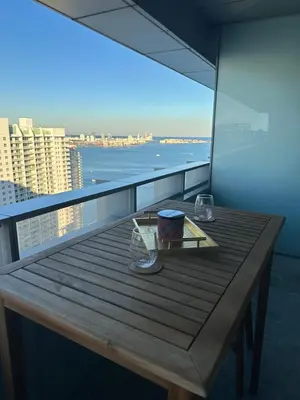 a table on a balcony with a view of the ocean at AKA Brickell Residences Free Parking by Palermo Home Miami in Miami