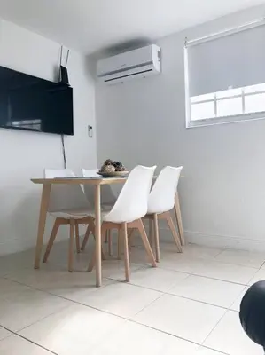 a dining room with a table and white chairs at Cozy and sweet home in Miami
