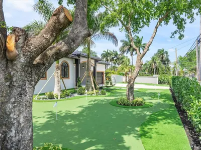 a house with a green lawn with palm trees at Villa ART Pool Golf Volleyball in Miami