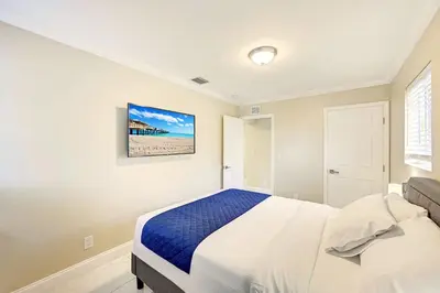 a bedroom with a bed and a painting on the wall at Tropical Oasis 6BR & 4BR Villa Heated Pool & Billiard Room in Hollywood