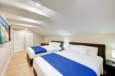 a hotel room with two beds with blue and white sheets at Tropical Oasis 6BR & 4BR Villa Heated Pool & Billiard Room in Hollywood