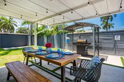 a patio with a table and chairs and a grill at Luxury Villa WALK 5 minutes to Hollywood Beach in Hollywood
