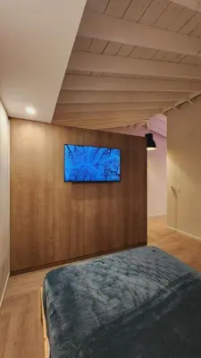 a bedroom with a tv on a wall at Private Home Studio Central Located in Miami 2 in Opa-locka