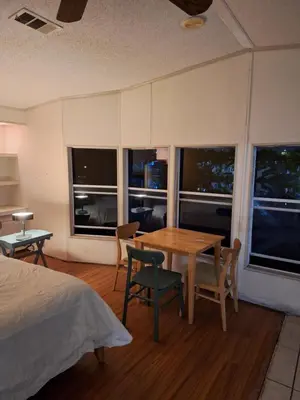 a bedroom with a table and chairs and windows at 1233 Apartment 1 Miami in Tamiami