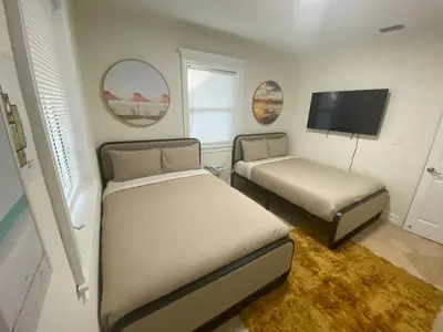 a bedroom with two beds and a flat screen tv at Entire home in Biscayne Park, Florida in Biscayne Park