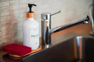a bottle of dish detergent sitting next to a sink at New Nordic Touch Loft, Central Location in Miami