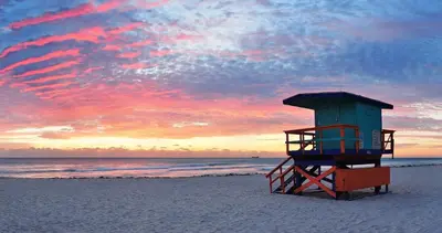 a lifeguard tower on the beach at sunset at Diane Oceanfront Suites in Hollywood