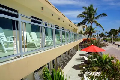 a hotel with a red umbrella next to a building at Diane Oceanfront Suites in Hollywood