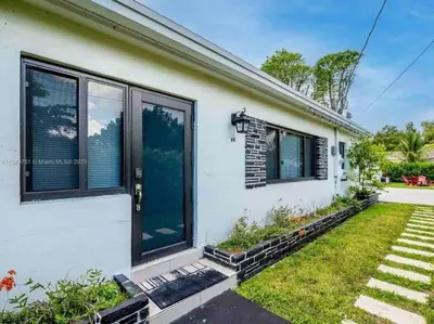 a white house with large windows and a yard at Charming house Miami in Miami